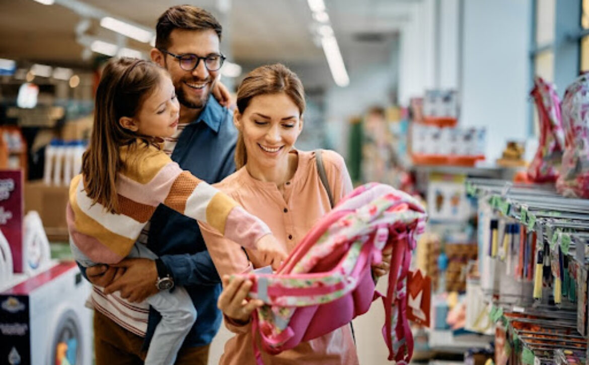 couple and their daughter looking at a school backpack in a store