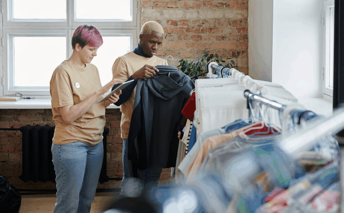 man and woman cataloging an article of clothing for donation for a thrift store