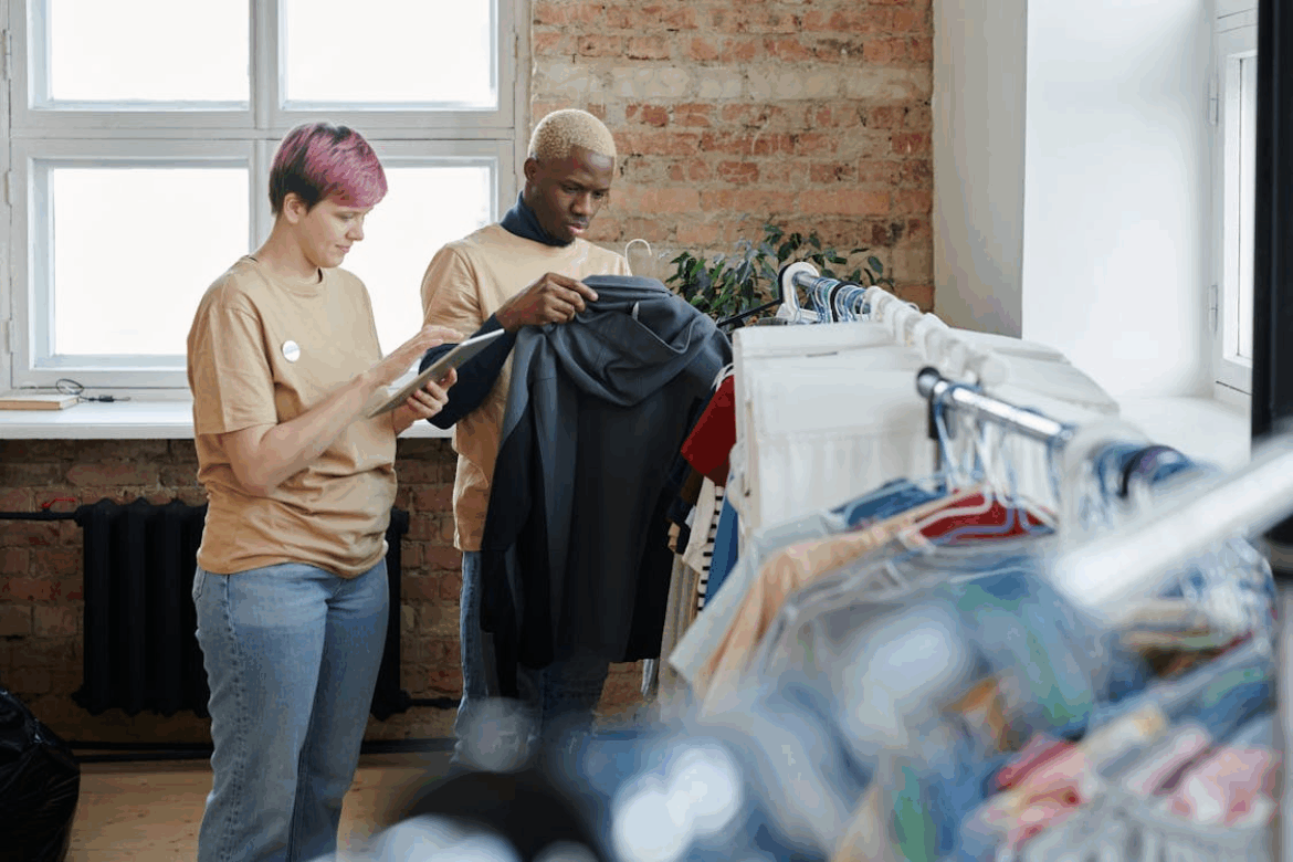 man and woman cataloging an article of clothing for donation for a thrift store